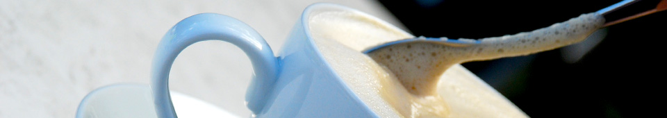 Große Tasse Café Latte die gerade umgerührt wird